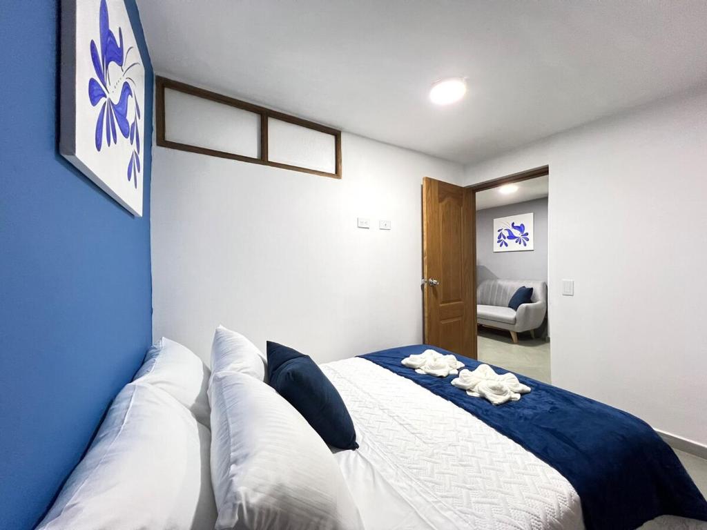 a bedroom with a blue and white bed with pillows at Apartamento Florelba - a dos cuadras del parque in Carmen de Viboral