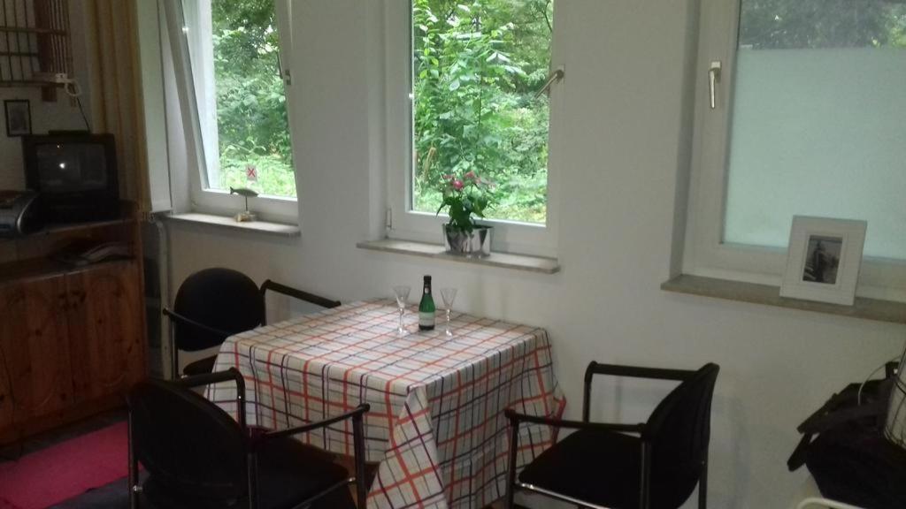 a dining room with a table with a bottle of wine at Simple Mini- Apartment City Park in Wismar