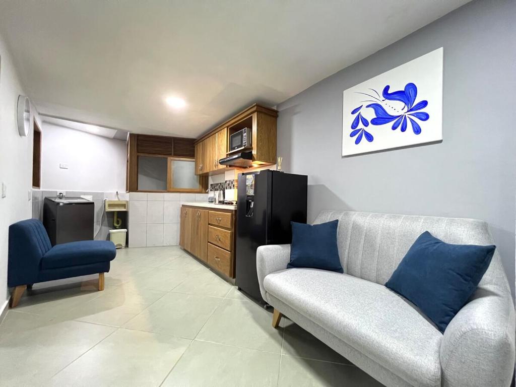 a living room with a couch and a kitchen at Apartamento Florelba - a dos cuadras del parque in Carmen de Viboral