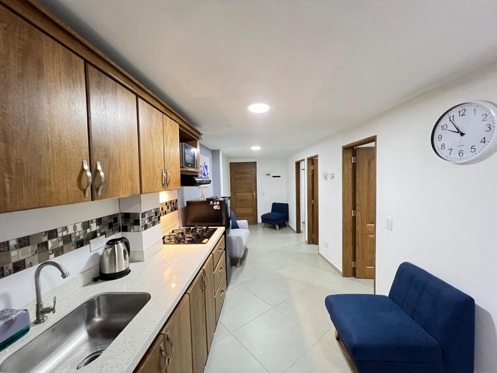 a kitchen with a sink and a clock on the wall at Apartamento Florelba - a dos cuadras del parque in Carmen de Viboral