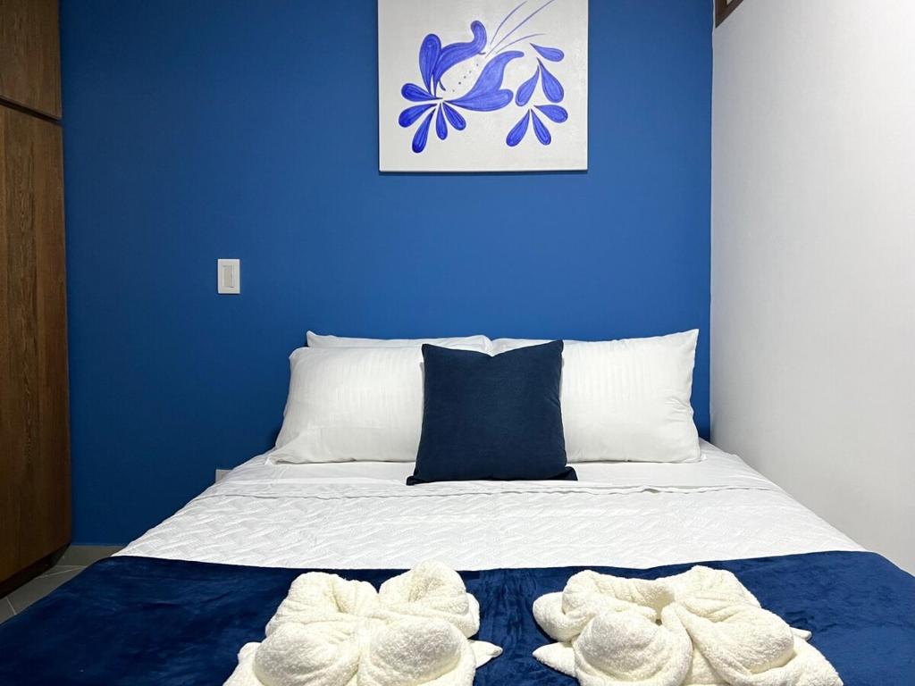 a blue bedroom with a bed with towels on it at Apartamento Florelba - a dos cuadras del parque in Carmen de Viboral