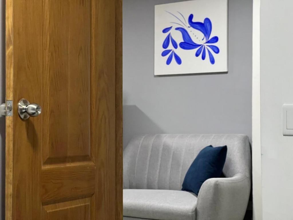 a room with a chair and a picture of a butterfly at Apartamento Florelba - a dos cuadras del parque in Carmen de Viboral