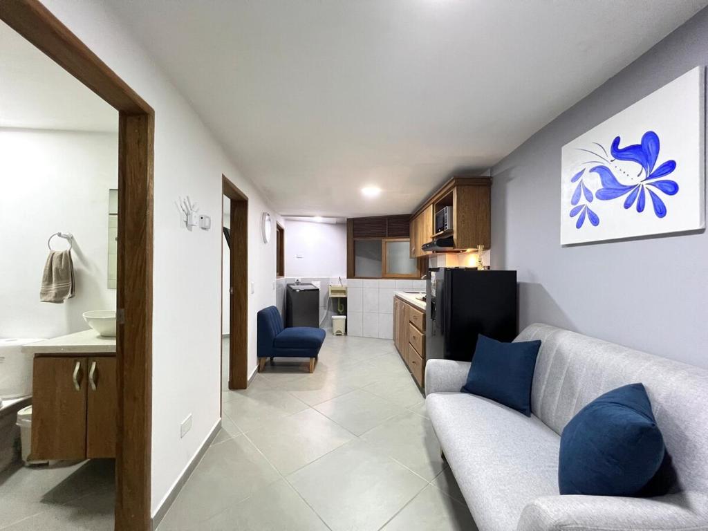 a living room with a couch and a kitchen at Apartamento Florelba - a dos cuadras del parque in Carmen de Viboral