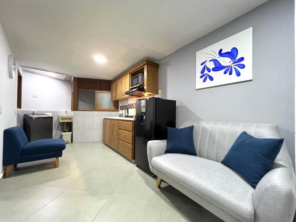 a living room with a couch and a kitchen at Apartamento Florelba - a dos cuadras del parque in Carmen de Viboral