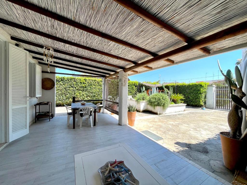 a patio with a wooden pergola and a table at Casa Kairos - Torre dell'orso in Torre dell'Orso