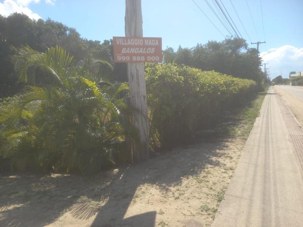 a street sign on a telephone pole on a road at Villagio Maga Bangalos in Conceição da Barra