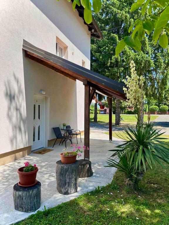 a house with a porch with pots of flowers at Guest house Ema in Grabovac