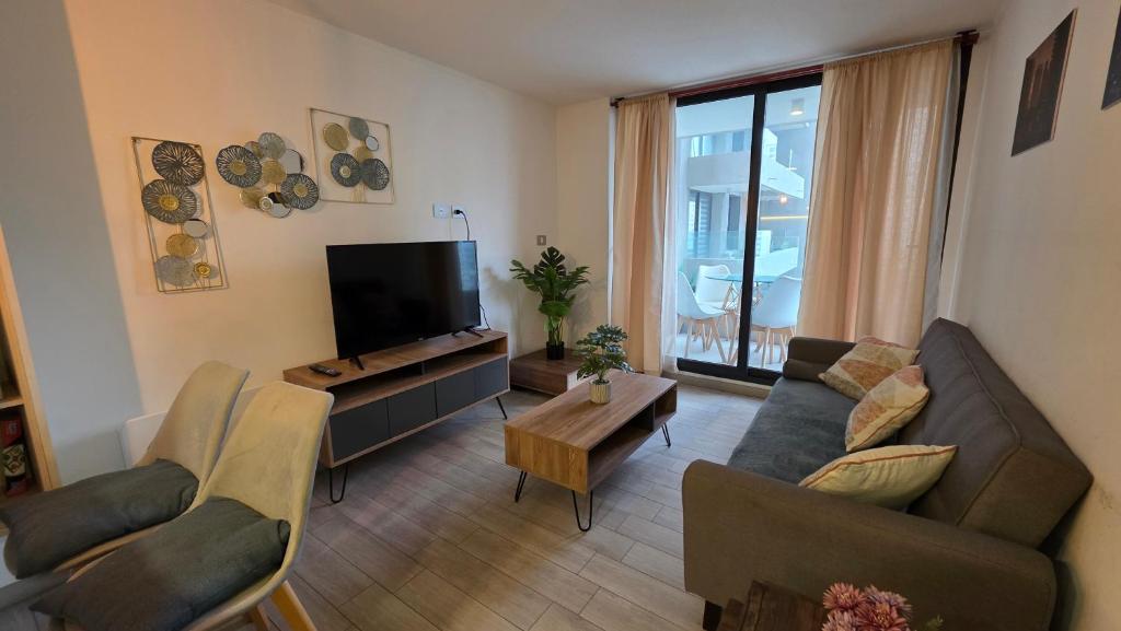a living room with a couch and a flat screen tv at Oceana Suites Eco Costas in Concón