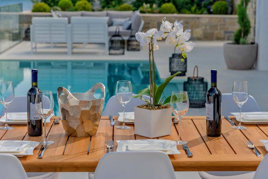 drewniany stół z kieliszkami do wina i rośliną w obiekcie Spectacular Korcula Villa 4 Bedrooms Villa Korcula Grandeur Private Infinity Pool Stunning Sea Views Zrnovo w Korčuli