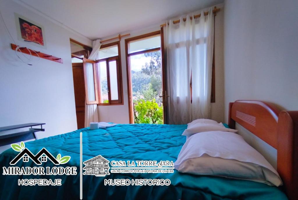 a bedroom with a blue bed with a window at Mirador Lodge in Chacas