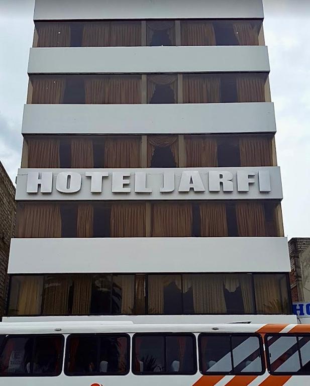 a bus is parked in front of a hotel at Hotel Jarfi in Hacienda El Recreo