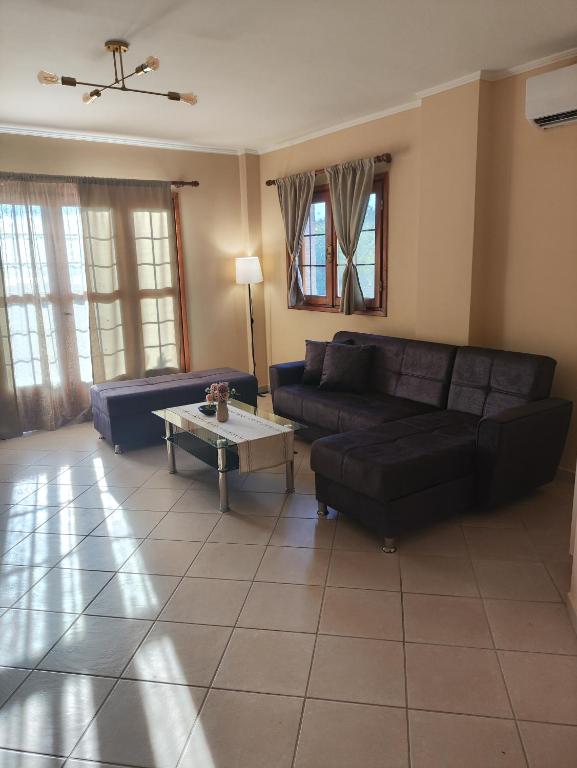 a living room with a couch and a table at Perdika Beige in Pérdika