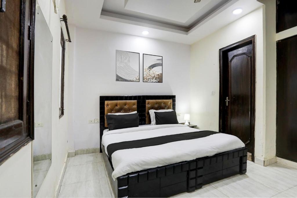 a bedroom with a large bed with white walls at Hotel O Metro Residency in New Delhi
