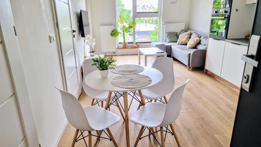 a small kitchen and living room with a table and chairs at Luxury in the city 6 Ksiezy Mlyn&FUZJA in Łódź