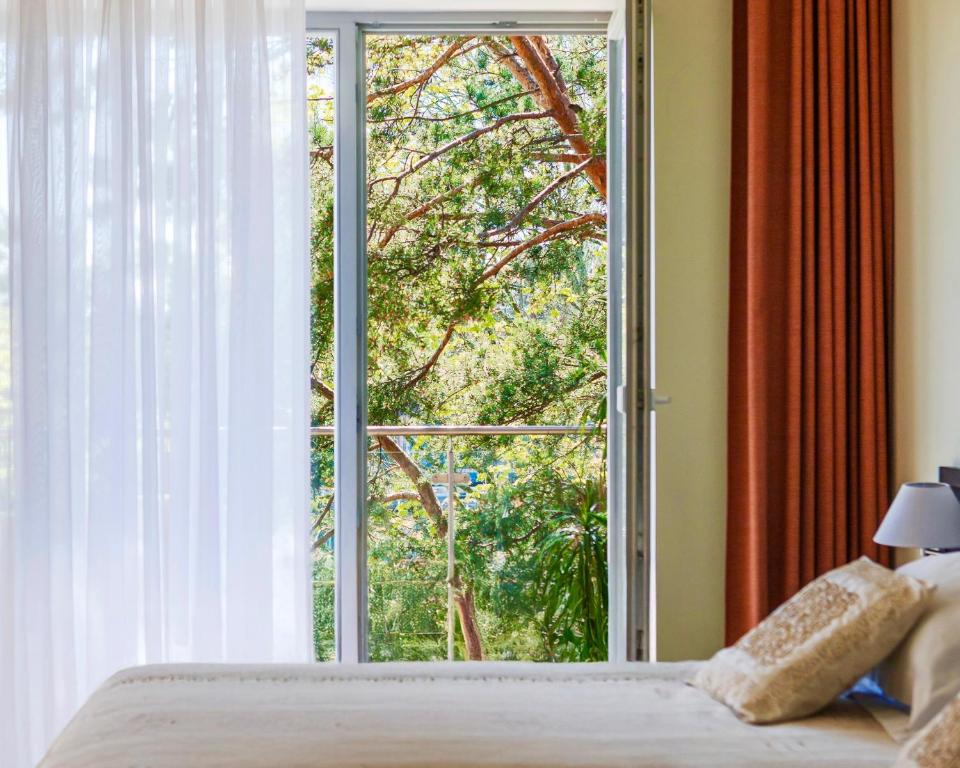 a bedroom with a window with a view of a tree at Baltic Inn in Palanga