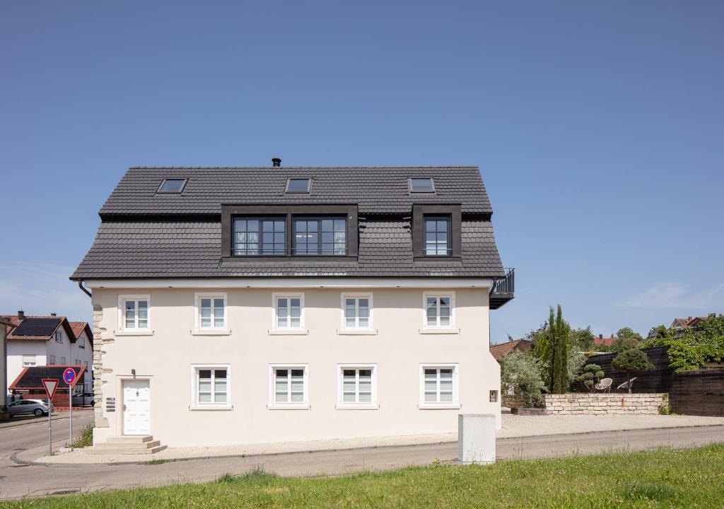 a white house with a black roof at Seehaus Allensbach - Riviera Suite in Allensbach