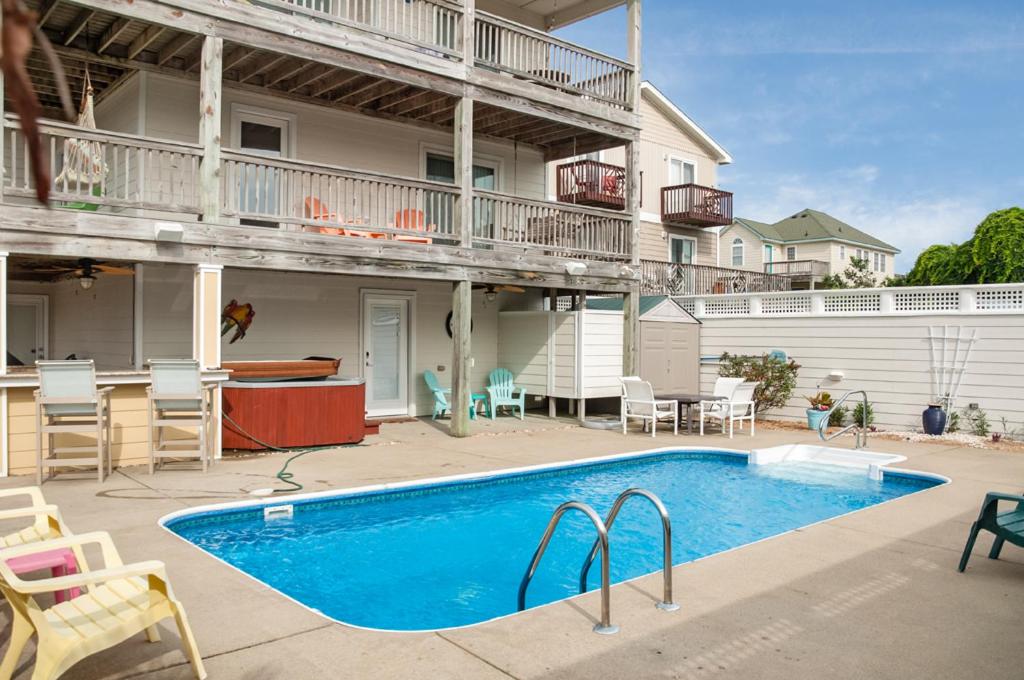 a swimming pool in front of a house at Weekend at Pinchys in Kill Devil Hills