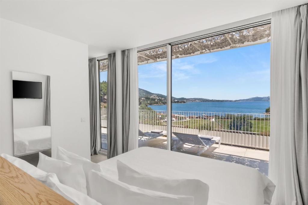 a bedroom with a bed and a view of the ocean at Radisson Resort Plaza Skiathos in Kanapitsa