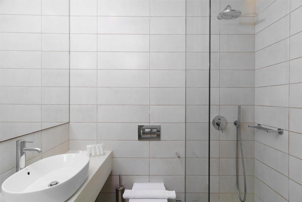 a bathroom with a shower and a sink and a toilet at Radisson Resort Plaza Skiathos in Kanapitsa