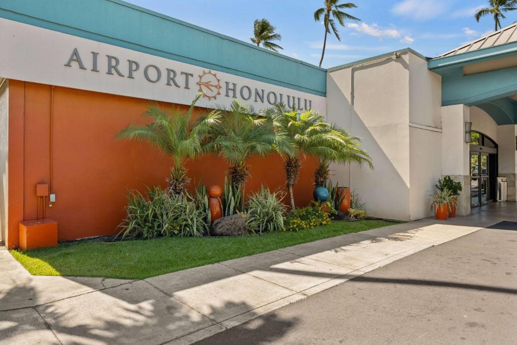 a front view of a hotel with palm trees at Airport Honolulu Hotel, Trademark Collection by Wyndham in Honolulu