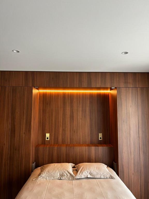 a bedroom with a wooden headboard and a bed at Core Luxembourg -Studio Parking -50 Cents in Luxembourg