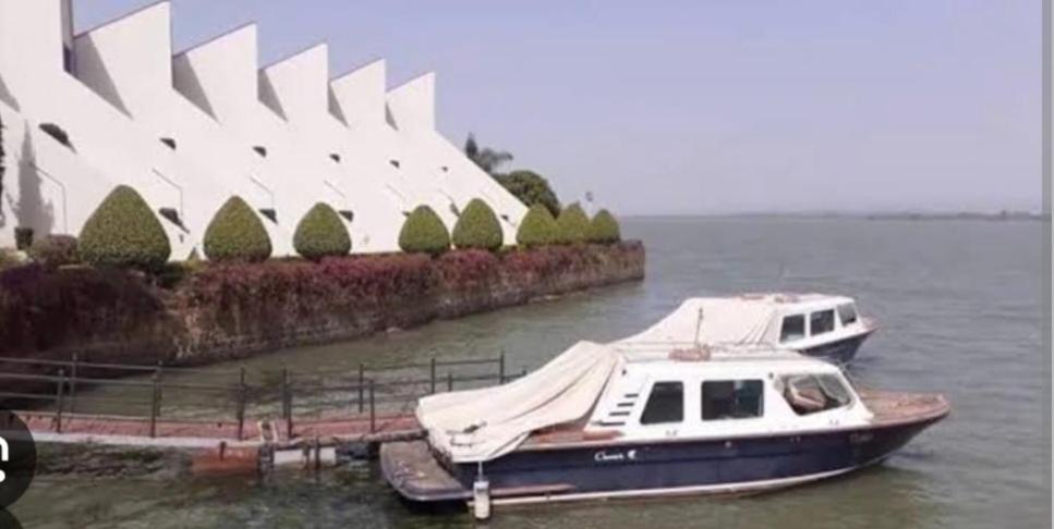 un barco está atracado en el agua frente a un edificio en Ethio Tours, en Bahir Dar