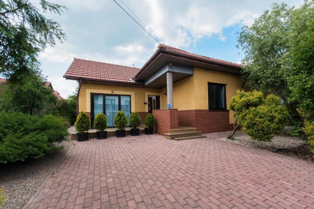 a house with a brick driveway in front of it at Carlson near Enerdgylandia in Zator