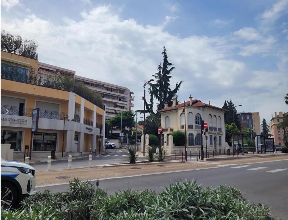 une rue de la ville avec un bâtiment et un arbre dans l'établissement 3P Appart, 10' from Palais Festival Cannes, au Cannet