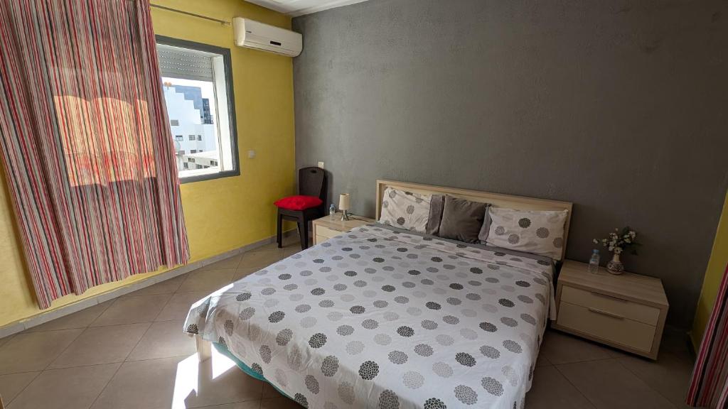 een slaapkamer met een bed en een raam bij Appartement meublée in Kenitra