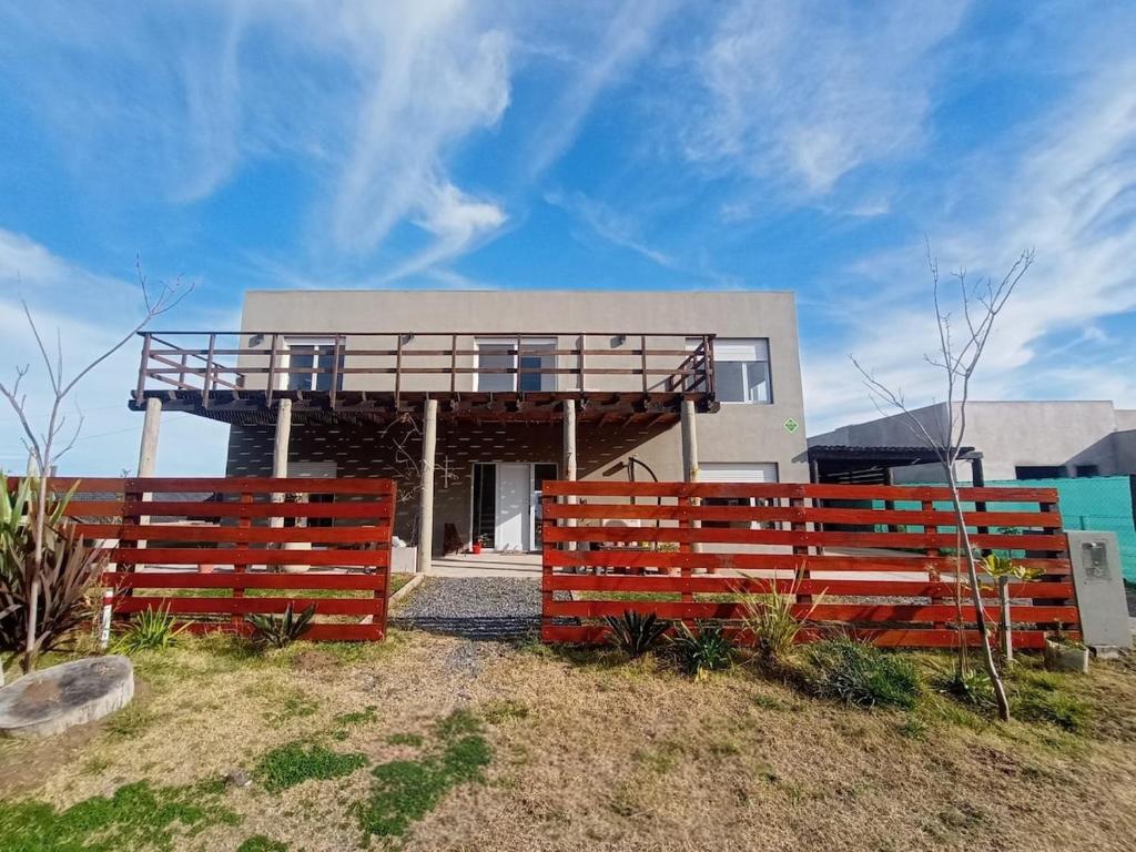 ein Haus mit einem Holzzaun davor in der Unterkunft Casa Grande para 7 personas in Balneario Claromecó