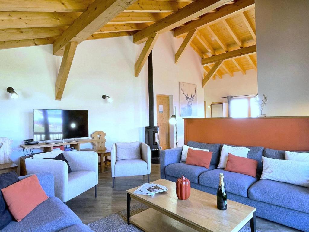 un salon avec des canapés bleus et une télévision dans l'établissement Chalet 12 pers, jacuzzi, sauna, ski-in, La Rosière - FR-1-690-27, à Montvalezan