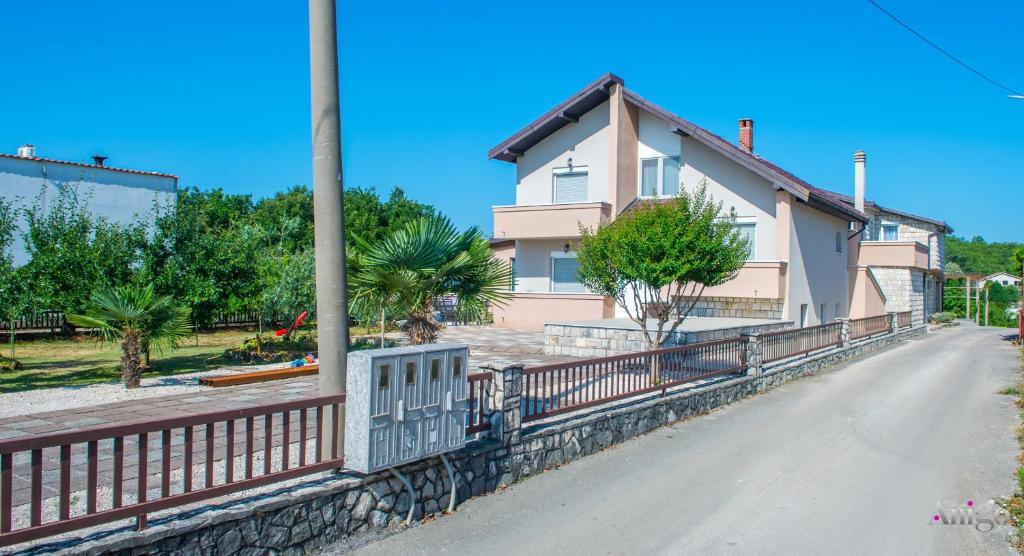 a house with a fence on the side of a road at Apartments Elle in Čitluk