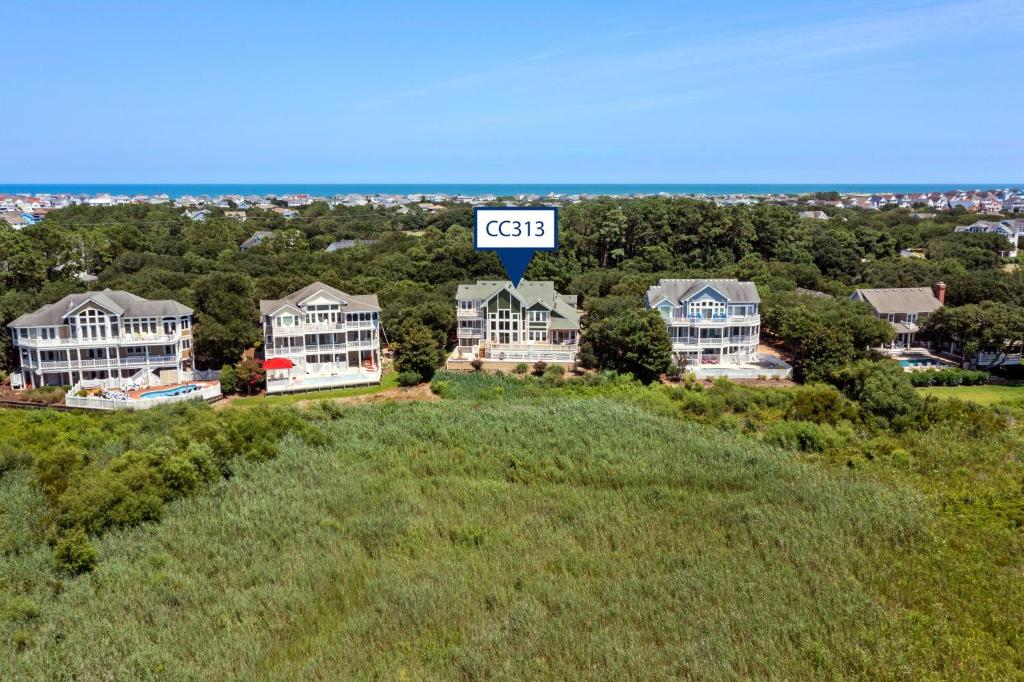a house on top of a hill with a cgi sign at Isle Of Skye by Village Realty in Corolla