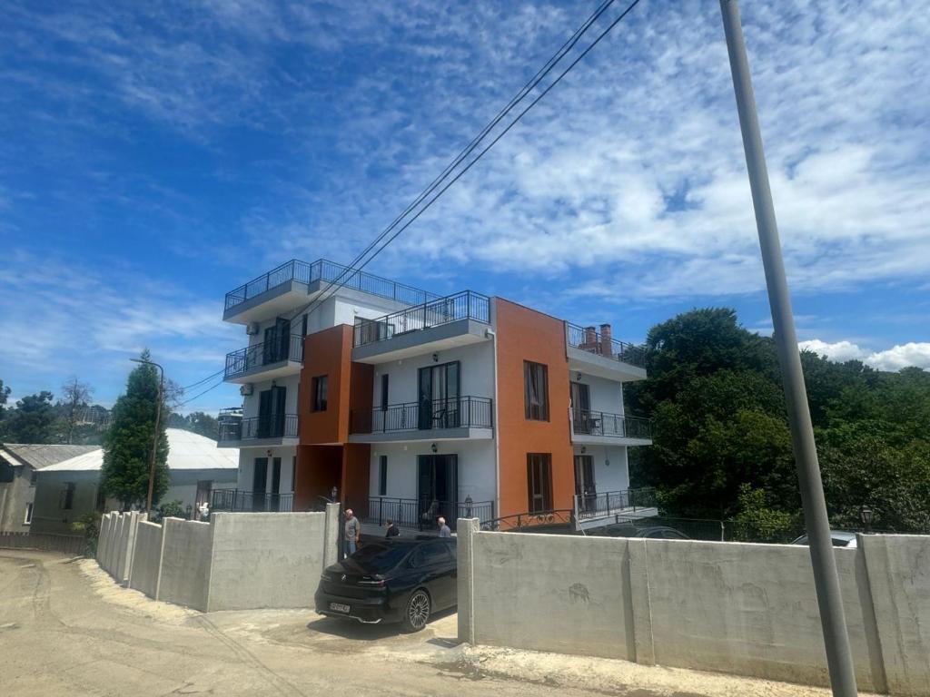 ein Gebäude mit einem davor geparkten Auto in der Unterkunft Mirza Guesthouse in Batumi