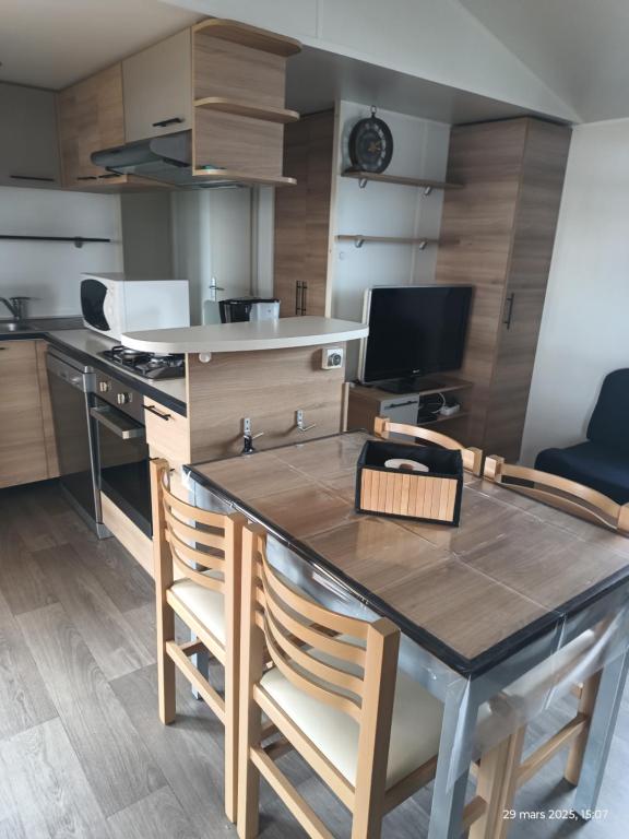 une cuisine avec une table et des chaises dans une pièce dans l'établissement Camping les sables du midi à Valras plage, à Valras-Plage