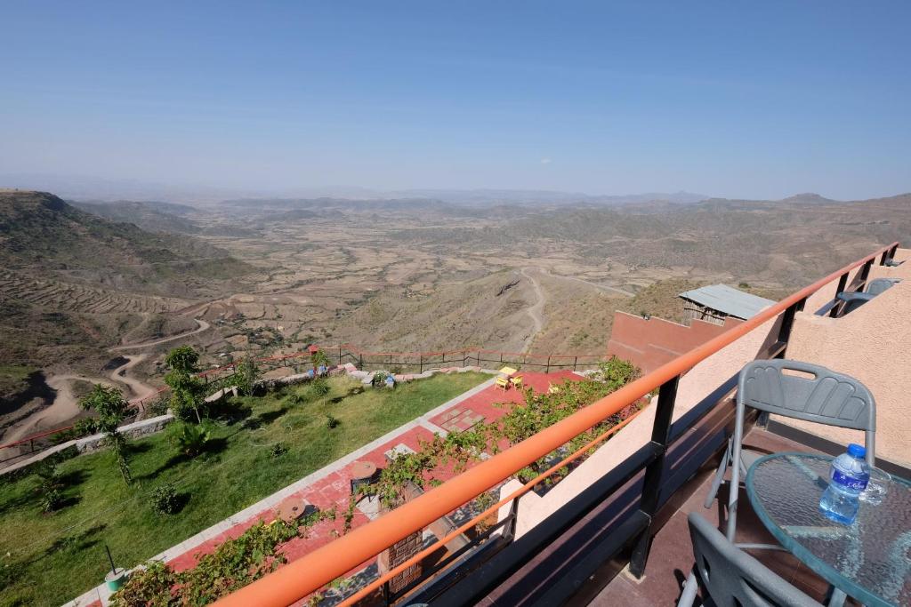 a view of a valley from a balcony with a bottle of water at Panoramic View Hotel in Lalībela