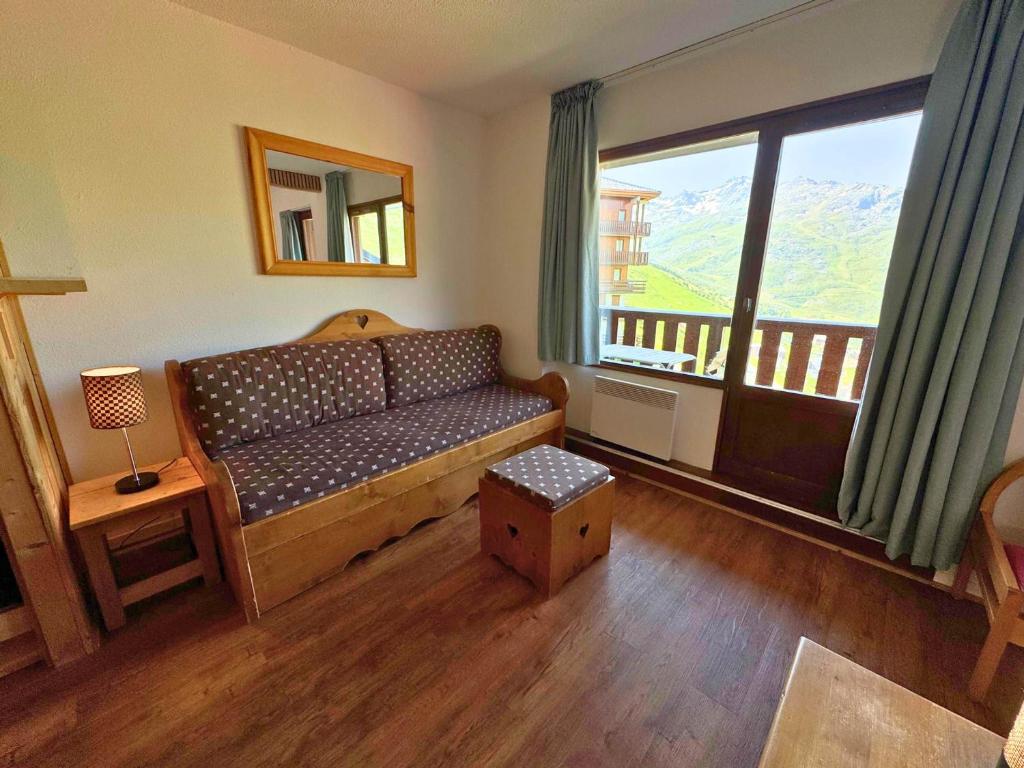 un salon avec un canapé et une grande fenêtre dans l'établissement Appartement confort pour 4 pers, en bord de pistes avec balcon, animaux admis - FR-1-452-265, aux Menuires