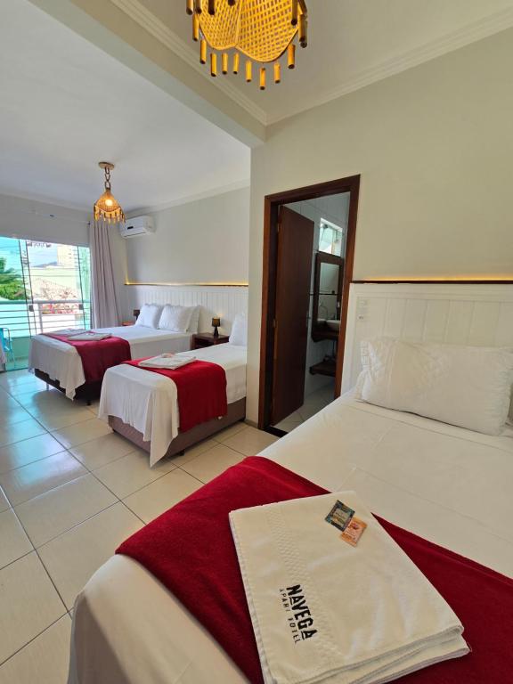 ein Hotelzimmer mit zwei Betten und einem Kronleuchter in der Unterkunft Navega Hotéis in Navegantes