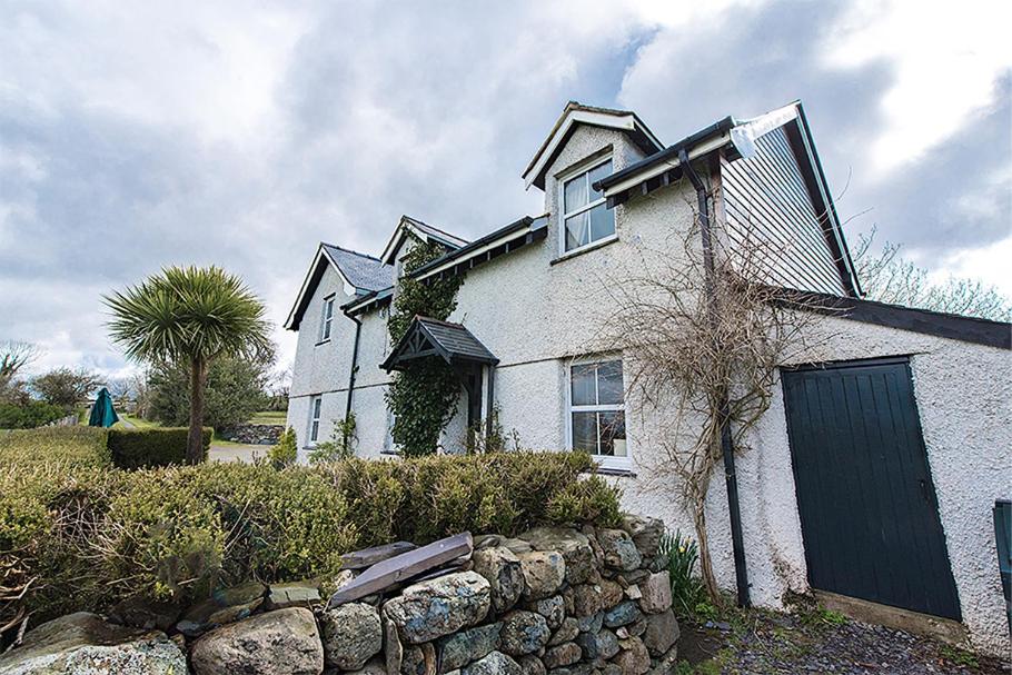 a white house with a stone wall at Perthi Uchaf in Llanberis