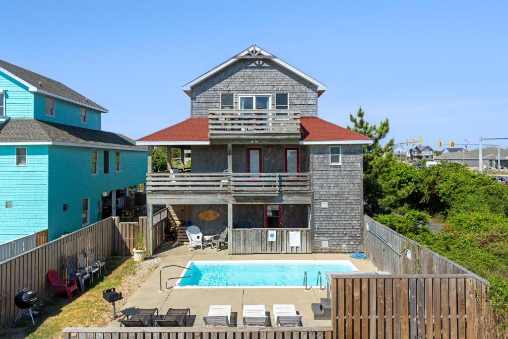 a house with a swimming pool in front of a house at Marlin Manor by Village Realty in Nags Head