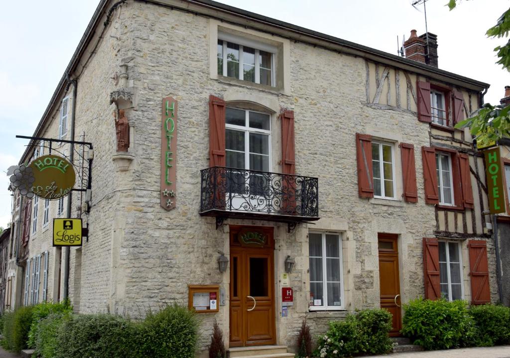 a stone building with a balcony on the side of it at Logis Le Saint Nicolas in Bar-sur-Aube