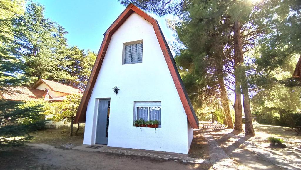 una piccola cappella bianca con una finestra e una porta di Complejo Cabañas Las Violetas en Villa Serrana La Gruta a San Andres de las Sierras