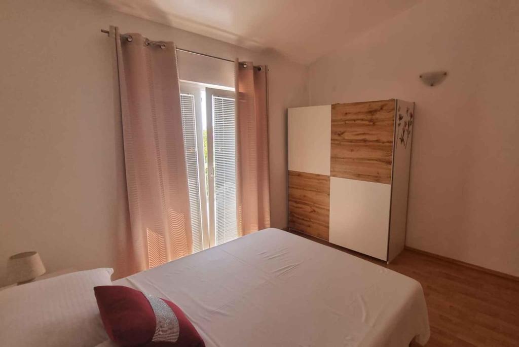 niewielka sypialnia z lodówką i oknem w obiekcie Apartment Vir 10 w mieście Vir