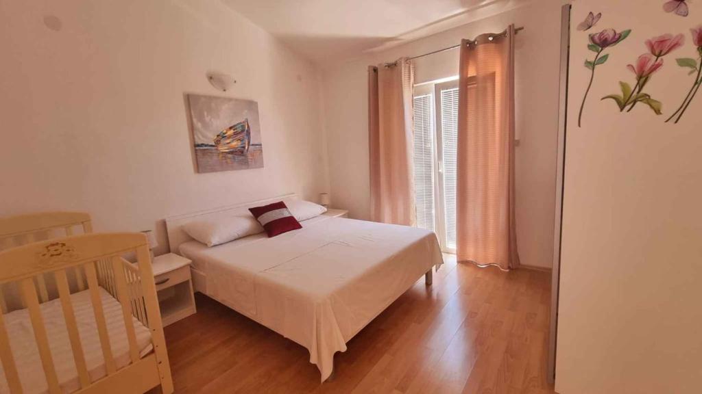 mała sypialnia z łóżkiem i oknem w obiekcie Apartment Vir 10 w mieście Vir