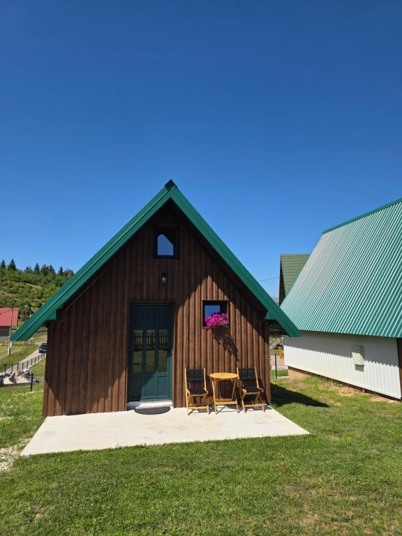 a barn with two chairs and a table in front of it at Green Valley in Žabljak