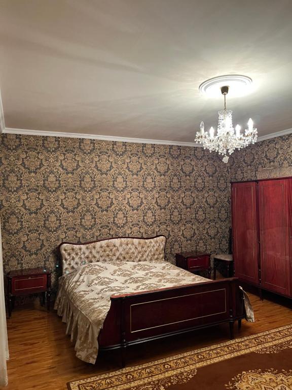 a bedroom with a bed and a chandelier at Дом in Bavra