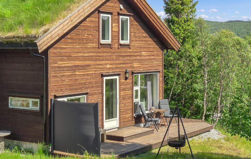 a log cabin with a deck and a table at 4 Bedroom Gorgeous Home In Edland in Vågsli