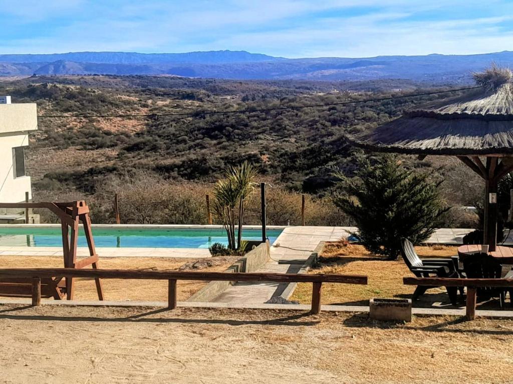 a view of a pool with a table and an umbrella at Ayres Serranos in Villa Carlos Paz