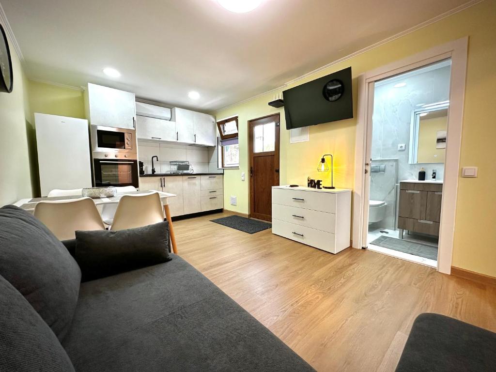 a living room with a couch and a kitchen at One-Bedroom House close to the Beach in Armação de Pêra