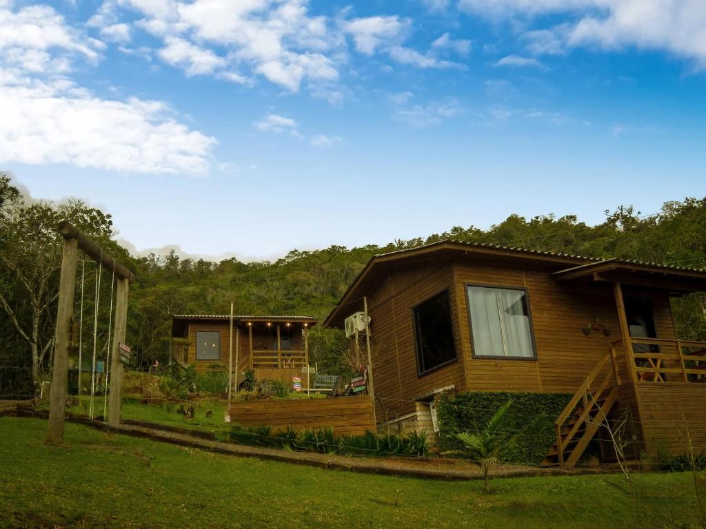 a log cabin with a porch and a house at Morada da Pedra in Praia Grande